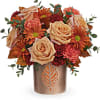 This autumn arrangement includes light orange roses, orange carnations, miniature maroon carnations