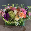 A centerpiece filled with Ecuadorian roses, premium hydrangeas, seasonal fillers, dahlias and
