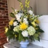 A funeral spray for the service filled with assorted yellow and white