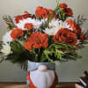 Roses carnations and white cushion pompous arranged in a ceramic gnome container