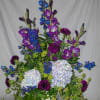 Purple Gladiolas, moon shadow carnations, blue hydrangea, Delphinium in an upright plastic