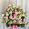 Beautiful pink and white vase arrangement featuring roses, carnations, fillers, orchids, and
