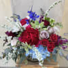 Japanese ranunculus, garden roses, and branches dance with spring joy in clear