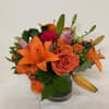 Orange lilies and orange roses, red roses with green
