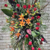This handcrafted memorial tribute contains Roses, Lilies, Gladiolus and a mixture of