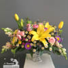 Beautiful blooms in gorgeous Spring colors cascade from clear chalice container. Our