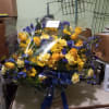 Bright yellow roses, carnations, daisies and alstroemeria mixed with blue irises, statice