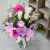 This spring bouquet has lilies, roses, snap dragon, and stocks in pink