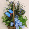 Blue bow, blue butterfly and blue silk flowers with assorted house plants
