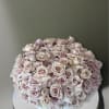 This arrangement comes in a clay round vase filled with quicksand roses