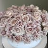 This arrangement comes in a clay round vase filled with quicksand roses