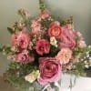 Natural and organic garden like arrangement of seasonal pink flowers, always containing