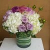 Pastel flowers in glass vase with ti leaf wrapped