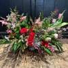 A Romantic mix of seasonal blooms in shades of red lavenders and