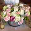 A low and lush arrangement overflowing with roses, hydrangeas, and various elegant