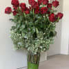 A beautiful glass vase filled with long stem Ecuadorian roses and seasonal