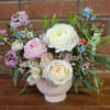 Modern vase dreamy and lush fresh arrangement with garden roses, blue tweediascabiosa