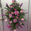 A collection of lavender and purple flowers arranged on a tall, standing