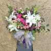 Beautiful arrangment featuring mums, lilies, roses, carnations, and green accents 