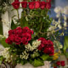 A beautiful arrangement consisting of Tie-Dye Red Roses, Stargazer Lilies, Wax flowers
