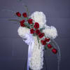 Funeral cross including white and red fresh flowers.
