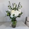 This beautiful arrangement includes hydrangeas, white roses, white stock, and mixed greens.
