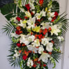 Red and white funeral spray with roses, oriental lilies, stock, snapdragons, alstroemerias