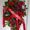 Purple and red funeral spray with roses, statice, carnations, and alstroemeria. 

(Picture