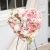 An all white and pink tribute, this heart shaped easel shows your