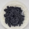 White candle with black face in the center 8x8