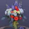 Pretty design including delphinium, rose, daisy, carnation and accents in a glass