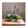 Large urn filled with beautiful flowers in shades of lavender, light blue