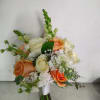 This wedding bouquet includes orange and white roses with greenery included and