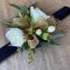 Wrist corsage Has small roses greenery and accents. Specify color desired of