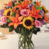 Orange lilies, carnations, alstroemeria, green button mums and hot pink roses with
