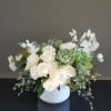A grand, all white and green arrangement featuring roses and succulents with