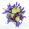A white box vase, green roses, and vivid blue iris make this