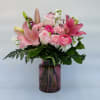 Pink blooms overflowing in a pink glass vase will make her day