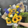 Mixture of sunflowers and compliment filler flowers in the brown paper wrapped