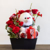 Roses arranged in a cascading form wrapping around a plush bear