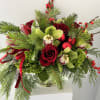 Beautiful arrangement filled with roses, orchids tulips, ilex berries Christmas greens