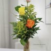 A pretty mix of three different color roses with greenery in a