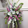 A sweet easel spray of pastel flowers. A nice way to send