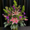 Arrangement includes Bells of Ireland, Stargazer Lily, Purple Carnations, Pink Tulips, Pink