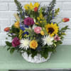 this white wicker basket is filled with roses, lilies sunflowers and a