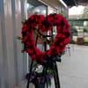 An open heart wreath with white carnations, Mums, and roses.
Color can be