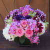 6&quot; sqare vase with lush arrangement in the pink/purple colors. Arrangement 
to