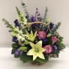 A nice assortment of purple, lavender and white flowers arranged together if