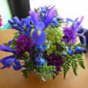 Square vase, contemporary look. Flowers included: Blue iris, green hydrangea,Purple carnations,Blue delphiniumAssorted