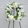 A beautiful wreath of seasonal blooms in white and greens.